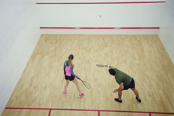 Two friends playing squash together