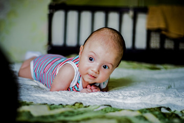 Sweet little baby is lying on the bed