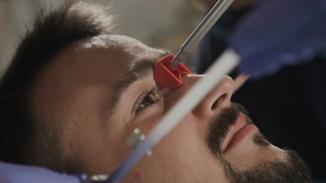 Young man at a dentist's appointment. Installation of the face-bow