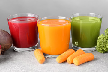 Glasses with various fresh vegetable juices on table