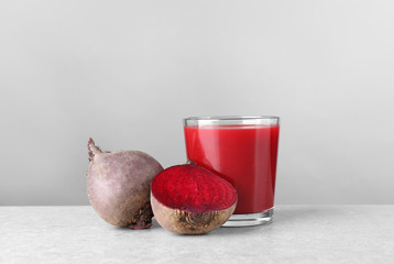 Glass of fresh beet juice on table
