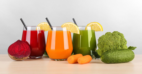 Glasses with various fresh vegetable juices on table