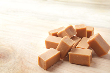 Sweet caramel candies on wooden background