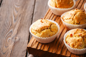 Homemade muffins with bacon and cheese on a wooden background. Healthy snack or breakfast meal.
