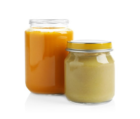 Jars with different baby food on white background