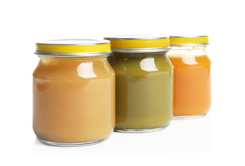 Jars with different baby food on white background