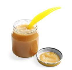 Jar with yummy baby food and spoon on white background