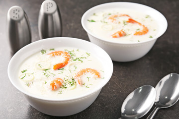 Tasty cream soup with fresh shrimps in bowls on table