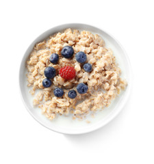 Bowl with yummy oatmeal and berries against white background