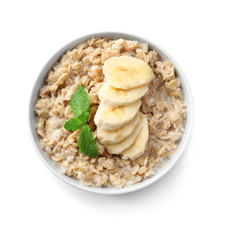 Bowl with yummy oatmeal and banana against white background