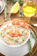 Tasty cream soup with fresh shrimps and croutons in bowl on table