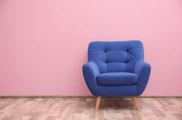 Blue armchair near color wall - obrazy, fototapety, plakaty