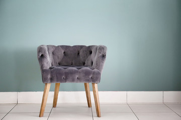 Comfortable armchair near grey wall