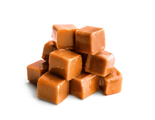 Tasty caramel candies on white background