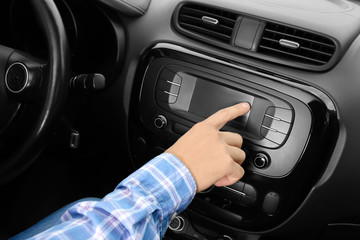 Man tuning radio in car
