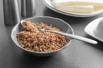 Bowl with cooked buckwheat on table
