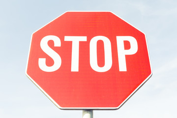 Regular standard stop sign on blue sky