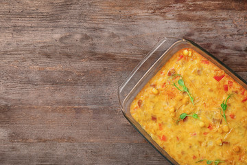 Baking dish with corn pudding on table