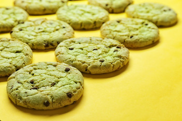 Mint chocolate chip cookies on yellow background, closeup