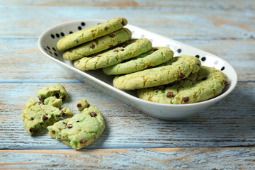 Plate with mint chocolate chip cookies on wooden table