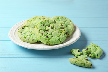 Plate with mint chocolate chip cookies on wooden table