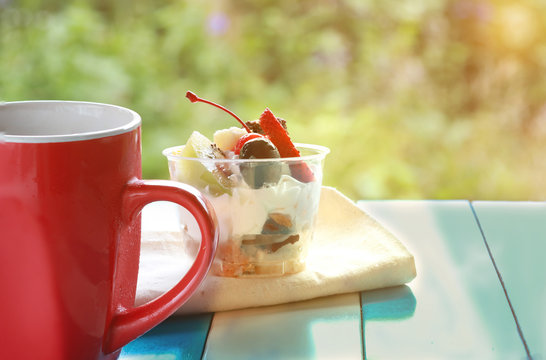 The Fruit Salad Cake And Coffee In Red Cup On The Table .