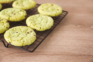Baking grid with mint chocolate chip cookies on wooden table