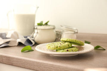 Plate with mint chocolate chip cookies on table in kitchen