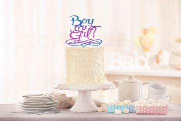 Stand with delicious cake for baby shower party on table indoors