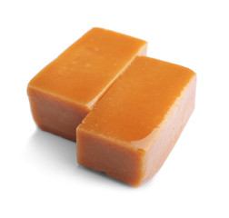 Delicious caramel candies on white background