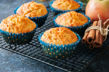 Homemade apple cheese muffins on a wire rack. Blue stone background. Seasonal baking.