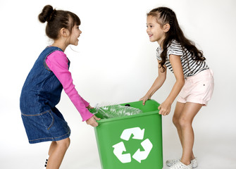 Two little girls moving a recycle box