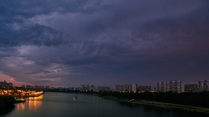 Cityscape at dusk with thunderstorm over apartments buildings