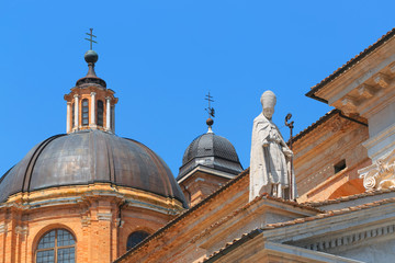 Fototapeta na wymiar Urbino, Italy - August 9, 2017: The Cathedral. Piazza Duca Federico. Sculpture and statue in architecture.