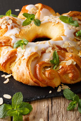 sweet brioche bun with glaze and almonds close-up. vertical