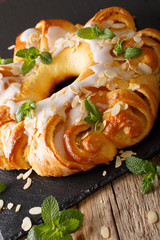 Festive sweet brioche with glaze and almonds close-up. vertical