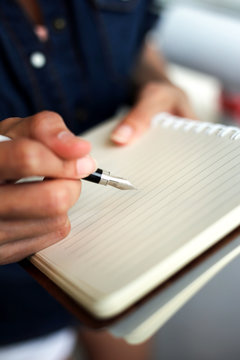 woman writing and taking note on notebook