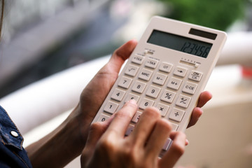 Closeup business woman hand using a calculator