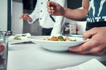 The chef prepares the dish. Try the cooked dish. Cooking. Professional kitchen. Salad dressing. Spices for salad