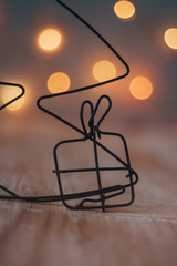 Fototapeta na wymiar Christmas gift made of wire with Christmas light-warm colors