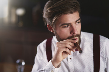 Portrait of businessman smoking a cuban cigar