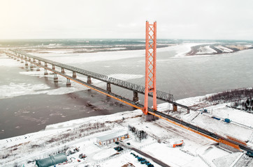 Fototapeta premium High road bridge over the river and railway bridge. view of the freezing river with ice.