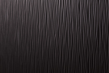 Wooden black undulating surface texture.