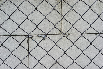 Hazard Prevention By building a metal barbed wire fence. The background is a wall of concrete blocks