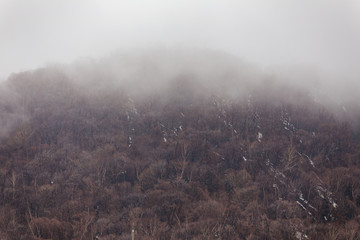 Mount Usu with snow and fog on the top and trees below near Noboribetsu Bear Park in Hokkaido, Japan.