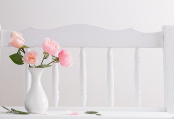 pink roses on vintage wooden white shelf