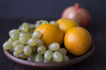 oranges and grapes on wooden background