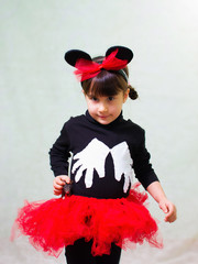 cute little girl in a bear costume with ears holds a hand rat