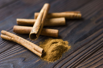 Cinnamon sticks and meal close up on wooden table