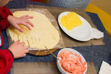 the child makes pizza for dinner
